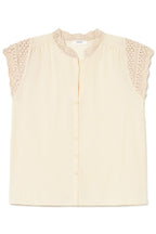 A cream-colored sleeveless blouse with a scalloped lace collar and lace detailing on the shoulders, featuring a button-down front.