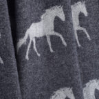 Pattern of running horses on a dark fabric background