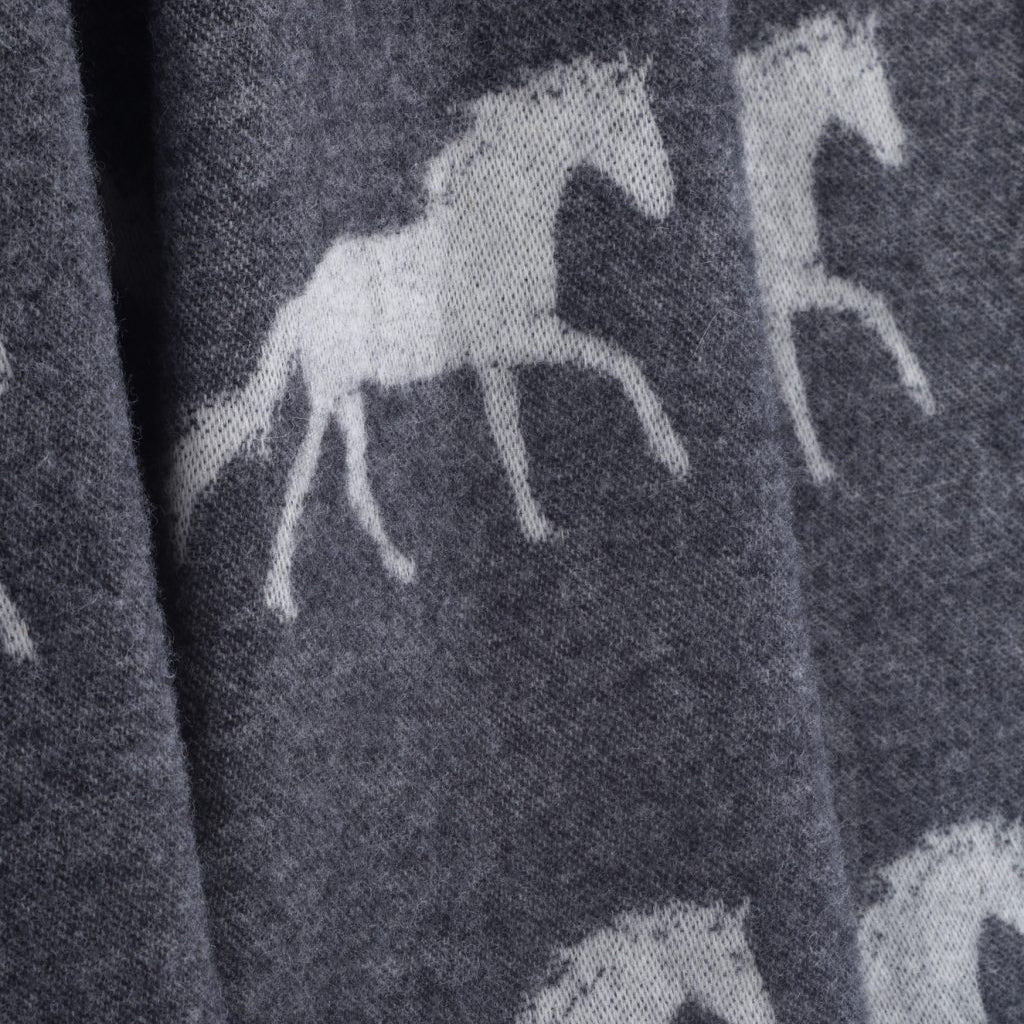 Pattern of running horses on a dark fabric background