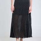 Person wearing a black pleated skirt with white stripes on a white background