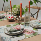 Elegant table setting with floral placemats, candles, and decorative elements.