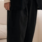 Person wearing a black suit with a blurred background