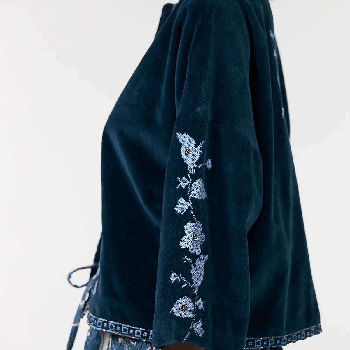 Dark blue kimono-style garment with floral embroidery on a plain background
