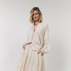 Woman wearing a beige outfit with a white background