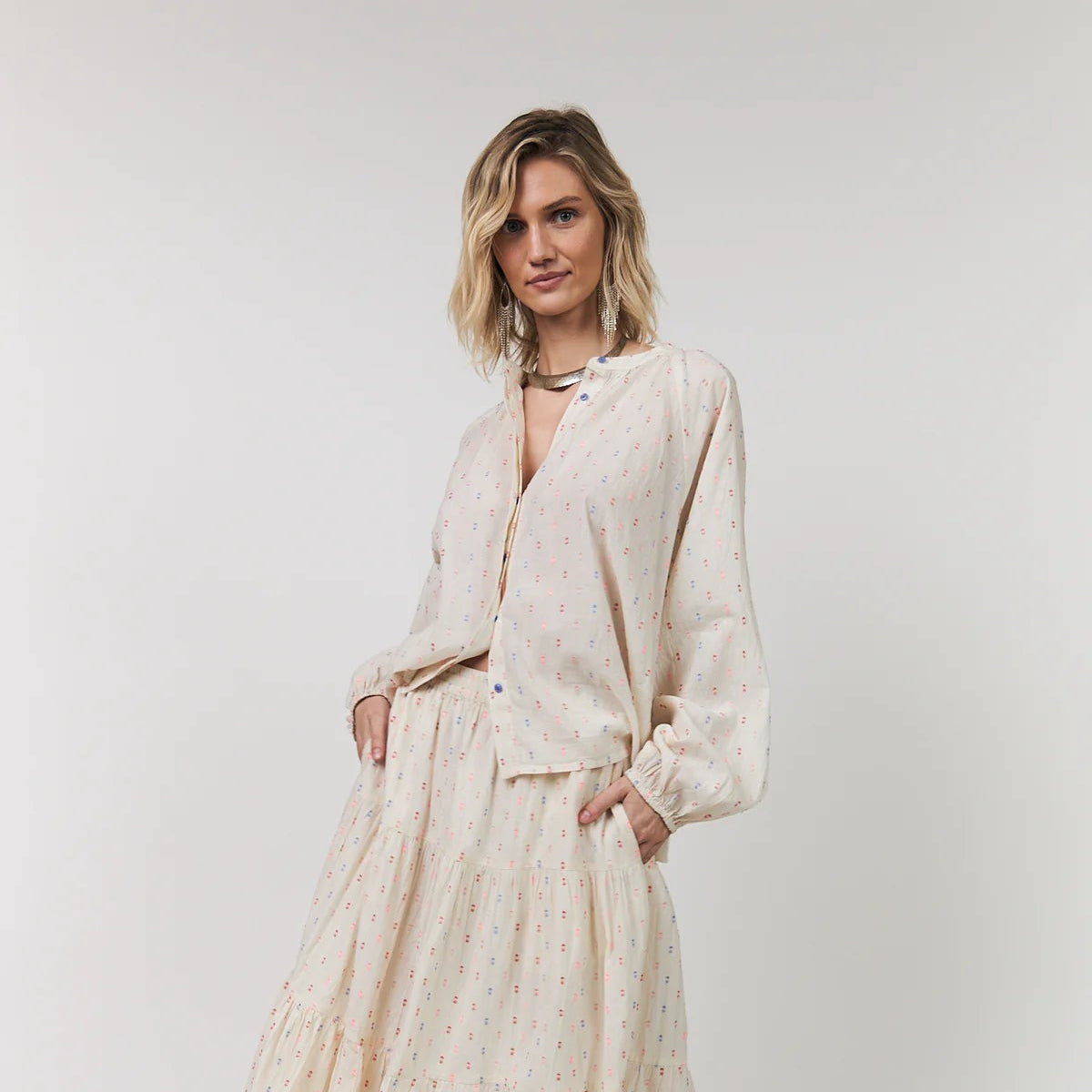 Woman wearing a beige outfit with a white background