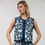 Woman wearing a blue floral dress against a plain background
