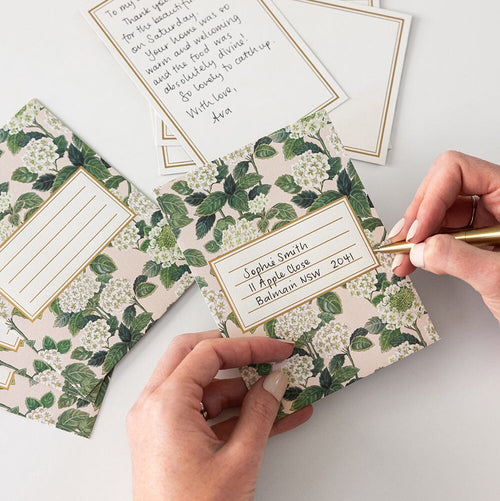 Floral stationery set with envelopes and cards on a light surface