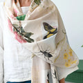 Person wearing a floral and insect patterned scarf with a white background
