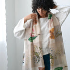 Woman wearing a floral-patterned scarf with a plain background