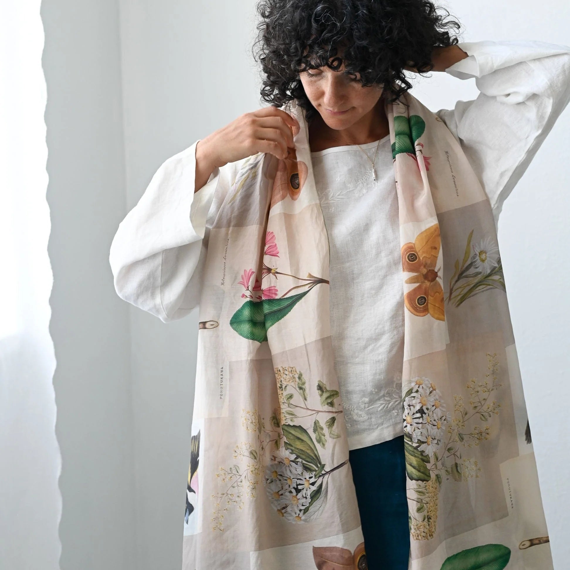 Woman wearing a floral-patterned scarf with a plain background