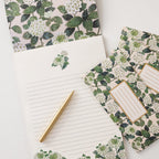 Floral-patterned paper with a pen on a white background