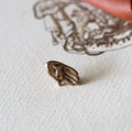 Small bronze figurine on a textured white surface with a red fabric background