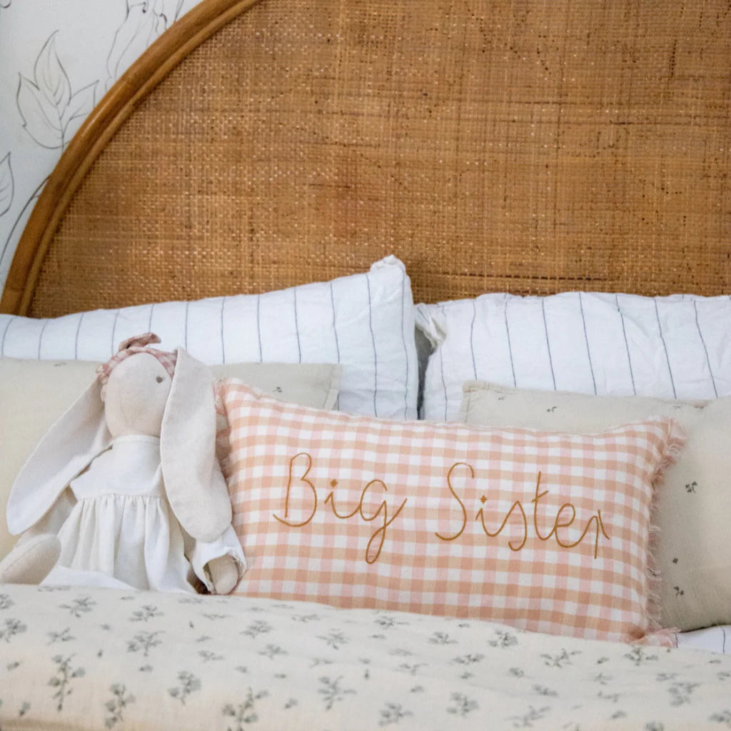Bed with 'Big Sister' pillow and wicker headboard