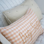 Checkered pillow with 'Big Sister' text on a bed